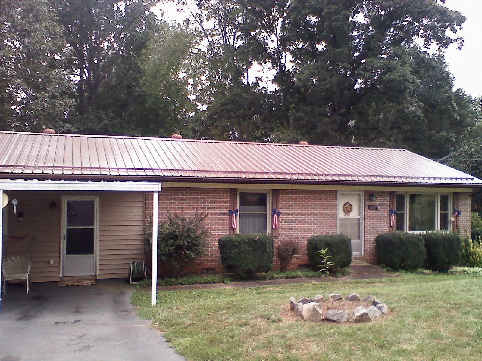 Bronze metal roof and carport on a brick ranch home — Roof Repair work by our crew in Custer